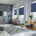Soft lit room with a desk, a bike, and Veneta™ Top-Down/Bottom-Up cellular shades in blue